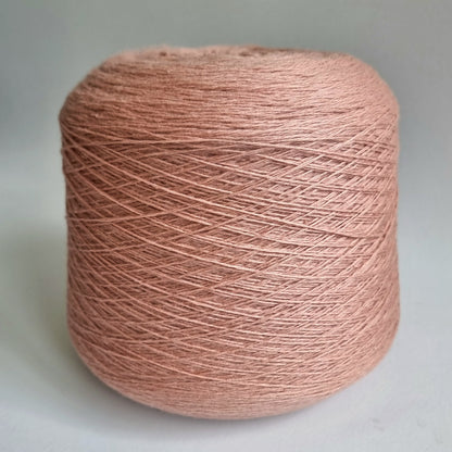 Spool of pink yarn on a light gray background